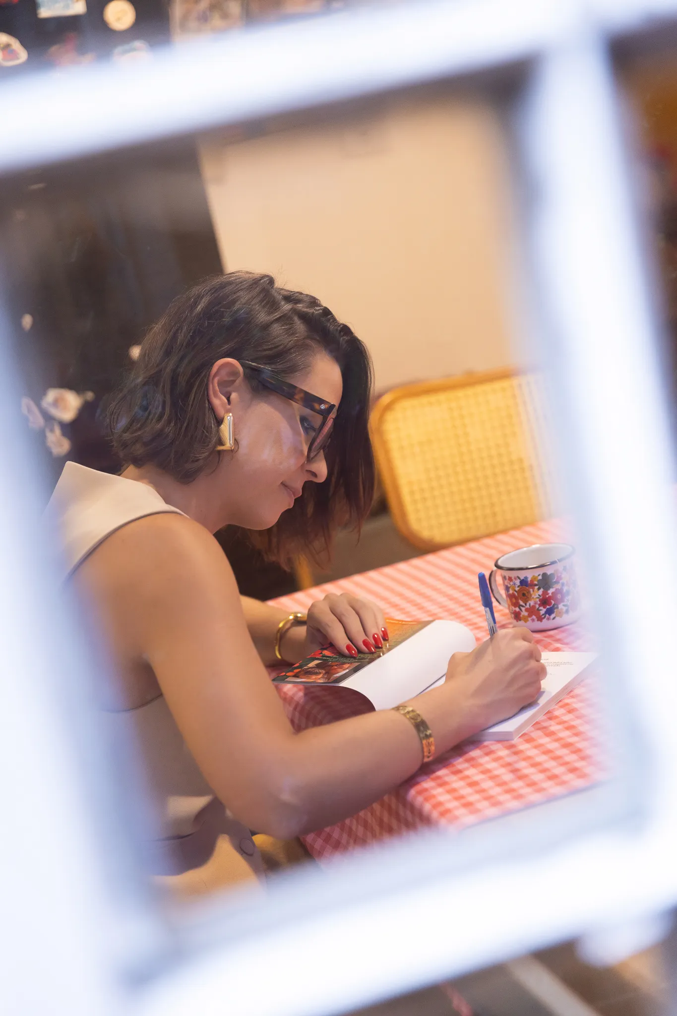 Nicole autografando um exemplar do livro Deixe o sol entrar